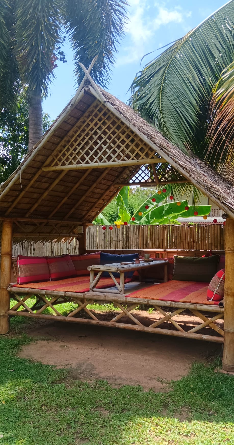 Shaded bamboo sala beside the palm trees