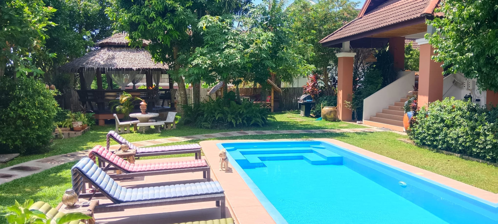 Swimming pool, sun loungers and Thai sala in the garden at Koh Shanti